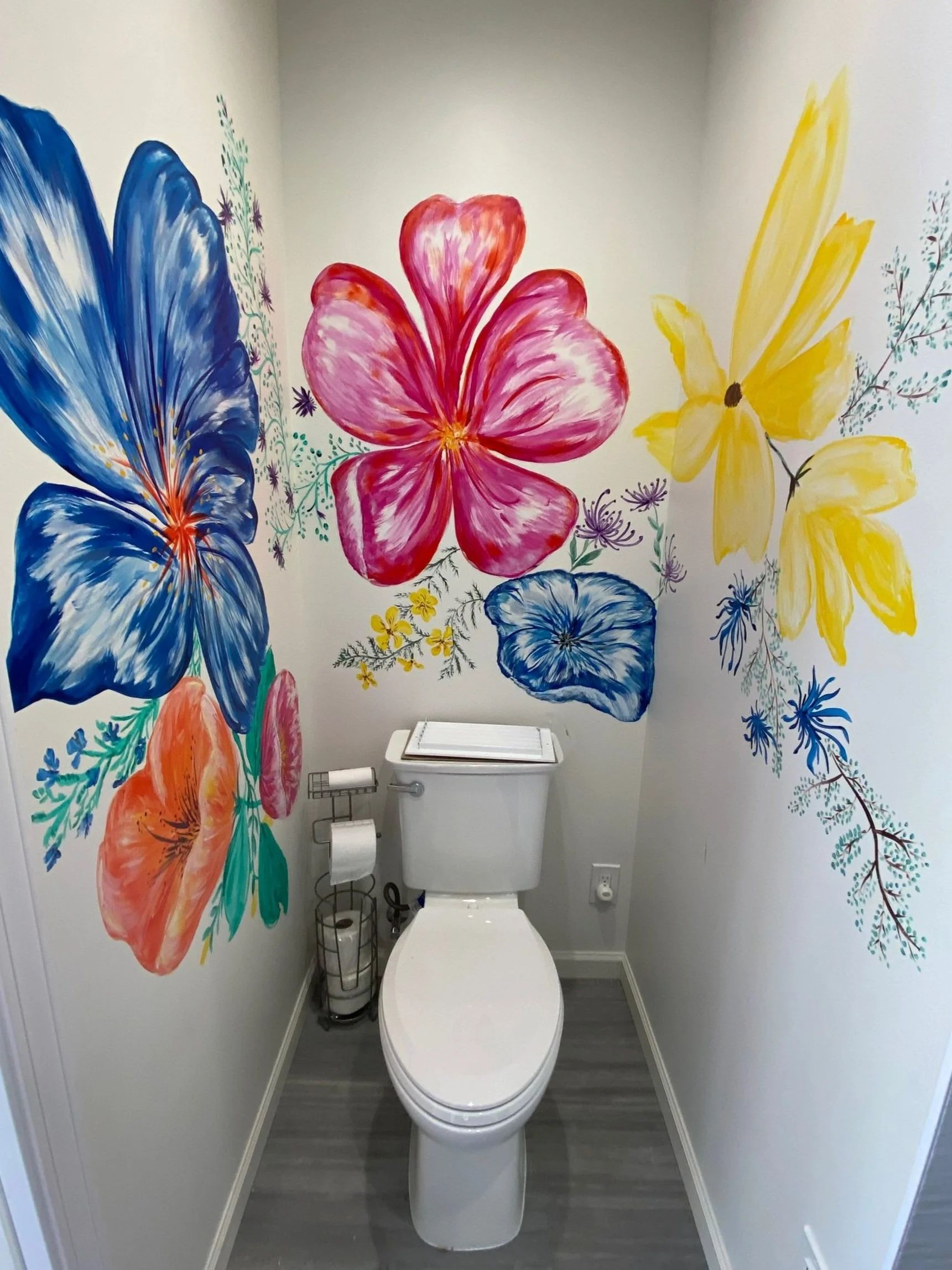 Powder room finished with a hand-painted floral mural covering two walls behind the toilet.